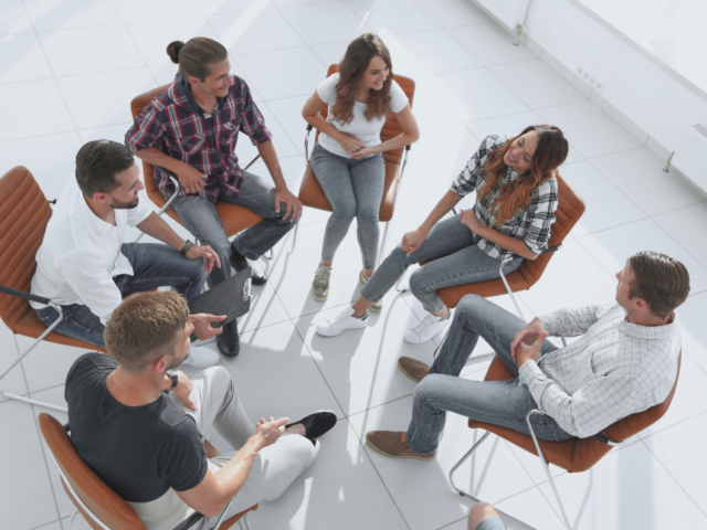 a group meeting seated on a circle of chairs